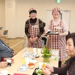 笑顔でお茶を運ぶ「ひと花」のメンバー（中央の２人）＝神河町粟賀町