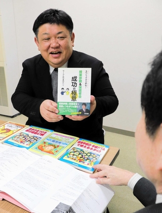 書籍や会報誌を並べ、活動の歩みを語るサークルやまびこの三原聖さん＝佐用町内