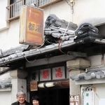 廃業となる都湯の玄関に立つ宮崎一一さん（左）と妻の悦子さん＝いずれも相生市相生３