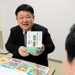 書籍や会報誌を並べ、活動の歩みを語るサークルやまびこの三原聖さん＝佐用町内