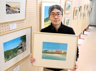 絵画展の会場で作品を手にする須飼秀和さん＝たつの市龍野町上霞城、霞城館