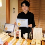 手作り商品の数々と塚崎正成さん。丁寧な仕事ぶりで最高賞を得た＝末廣堂光都苑