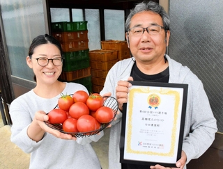 全国トマト選手権で銀賞に輝いた竹田農園のトマトと竹田吉礼代表（右）＝たつの市揖保川町市場