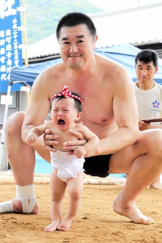土俵で元気に泣き声を上げる赤ちゃん＝南町荒神社