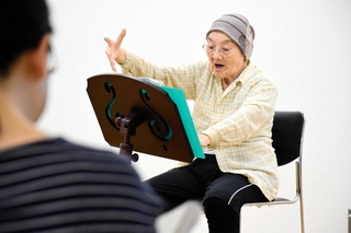 合唱団「露風を謳う」で指揮者を務める島津たづさん。本番も着座で指揮を執る＝たつの市龍野町立町