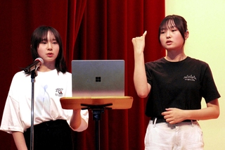 チーム紹介文を読み上げる山本ひまりさん（左）と手話通訳をする姉のほのかさん＝福崎町高岡