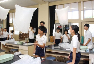 教室を飛ぶミニ気球に喜ぶ高岡小の児童と福崎高校生＝福崎町高岡