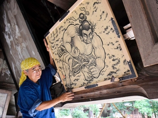 野見宿禰を描いた絵馬を設置する谷口秀作さん＝たつの市龍野町日山