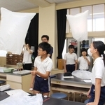 教室を飛ぶミニ気球に喜ぶ高岡小の児童と福崎高校生＝福崎町高岡