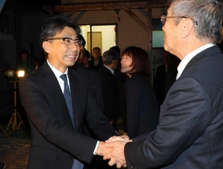 当選確実の一報を受け、支援者と握手する江見秀樹氏（左）＝２６日夜、佐用町佐用（撮影・後藤亮平）