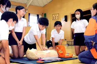 消防団員から心肺蘇生の方法を教わる児童＝福崎町西田原
