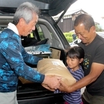 町地域農業担い手協議会のメンバー（左）から米を受け取る保護者ら＝神河町寺前