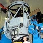 「なゆた望遠鏡」（奥）の未来技術遺産登録を喜ぶ伊藤洋一・県立大学西はりま天文台センター長＝佐用町西河内