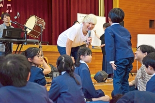 卒業ソングの制作のため、児童から学校の思い出などを聞き取る音楽ユニット「秋休」のボーカル平松契帥さん（中央）＝東栗栖小