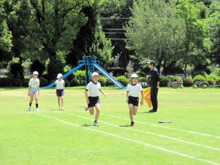 運動場の芝生の上を走る児童ら（相生市教育委員会提供）＝矢野小学校