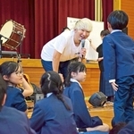 卒業ソングの制作のため、児童から学校の思い出などを聞き取る音楽ユニット「秋休」のボーカル平松契帥さん（中央）＝東栗栖小