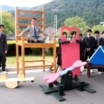 高校生が作った巨大椅子の座り心地を確かめる山名宗悟町長（中央）＝神河町寺前
