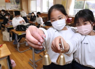 配布された「熊鈴」を手にする児童。早速、ランドセルに付けて下校した＝宍粟市山崎町鹿沢、山崎小学校