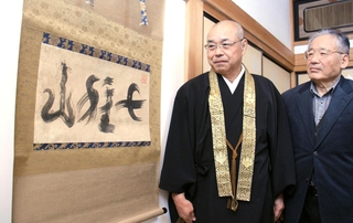 中塚廣重さん（右）から「七種山」の書を受けた寺河俊紀住職＝福崎町田口