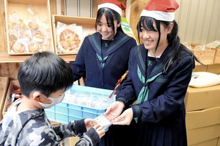 大阪・関西万博のイタリア館レストランから提供された小麦粉で作ったクッキーを配る上郡高校生ら＝赤穂市加里屋