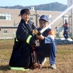 防火服を着て放水を体験する子ども＝市川町西川辺