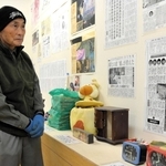 阪神・淡路大震災で犠牲になった長女志乃さんの遺品を展示する上野政志さん＝佐用・三河小アートセンター