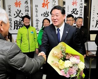 比例復活が決まり、支援者と握手を交わす池畑浩太朗氏（中央）＝たつの市龍野町富永