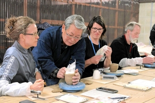 長棟州彦さんから雲火焼の作り方を学ぶ訪日ツアー客＝赤穂市御崎