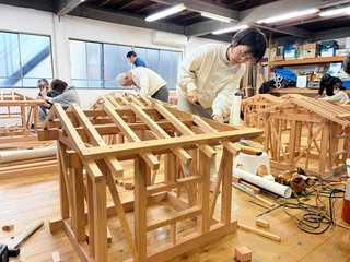 真剣な面持ちで木造のミニハウス製作に取り組む受講生ら＝たつの市龍野町日飼（西播建設業組合提供）