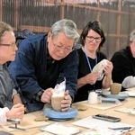 長棟州彦さんから雲火焼の作り方を学ぶ訪日ツアー客＝赤穂市御崎