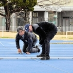 公認の更新のため、新調されたトラックレーンをチェックする日本陸上競技連盟の検定員ら＝太子町佐用岡