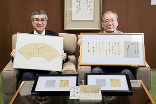福崎町に井上通泰の史料を寄贈した中塚廣重さん（右）。左は尾﨑吉晴町長＝福崎町役場