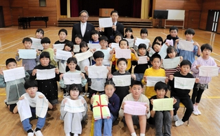 寄贈された手縫いのぞうきんを掲げる児童たち＝赤穂西小学校