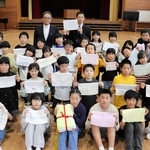 寄贈された手縫いのぞうきんを掲げる児童たち＝赤穂西小学校