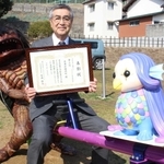 辻川山公園に新設されたシーソーに座って表彰を喜ぶ尾﨑吉晴町長とガジロウ＝福崎町西田原