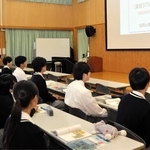 佐用山城ガイド協会の春名政男会長（右）から利神城跡の歴史などについて説明を受ける生徒たち＝太子町糸井、太子高校