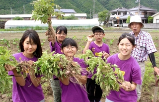 中野二郎さん（右端）の畑のジャガイモを手にする神戸の子どもたち＝宍粟市山崎町岸田
