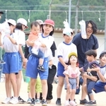 駆けっこに参加した未就学児を抱っこして、手作りのプレゼントを選んでもらう児童ら＝市川町上瀬加