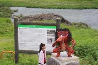 市川の駒ケ岩（看板の奥）前に設置されたガジロウの模型＝福崎町南田原