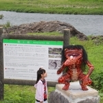 市川の駒ケ岩（看板の奥）前に設置されたガジロウの模型＝福崎町南田原