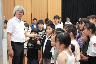 菊池省三さん（左）の進行のもと「アンパンマン」を題材に人との関係づくりについて考える子どもたち＝市川町文化センター