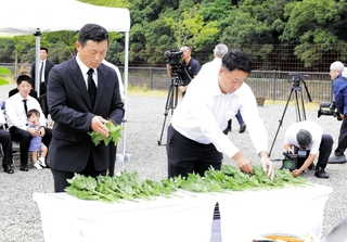 犠牲者を思い、花を手向ける佐用町議の重田直人さん（右）＝佐用町久崎、復興ひろば