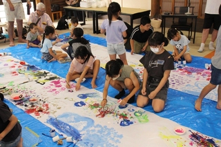 大きな紙の上に自由な発想で絵を描く子どもたち＝福崎町南田原