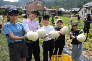 「重い」「白い」と話しながらカボチャの豊作を喜ぶ子どもたち＝神河町粟賀町