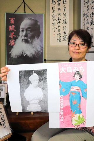 大鳥みちのアニメ画と、胸像の写真のコピーを持つ中川由香さん。背後には、大鳥圭介の肖像が掲げられている＝上郡町岩木丙、いきいき交流ふるさと館