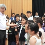 菊池省三さん（左）の進行のもと「アンパンマン」を題材に人との関係づくりについて考える子どもたち＝市川町文化センター