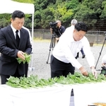 犠牲者を思い、花を手向ける佐用町議の重田直人さん（右）＝佐用町久崎、復興ひろば