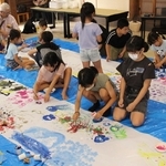 大きな紙の上に自由な発想で絵を描く子どもたち＝福崎町南田原