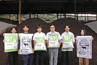 竹チップと牛ふんが入った堆肥を開発した近畿農産資材と神戸学院大学のメンバー＝佐用町山脇