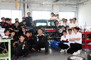 ミニ・クーパーをＥＶに改造している龍野北高の生徒（右側の白いシャツ）と日本工科大学校の学生たち＝姫路市兼田